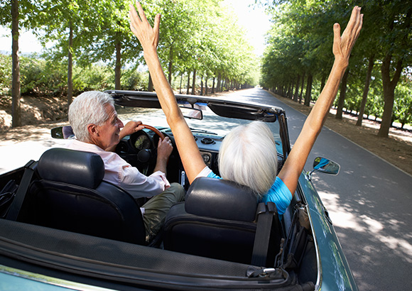 couple enjoying convertible car with the cheapest car insurance in Burlington.